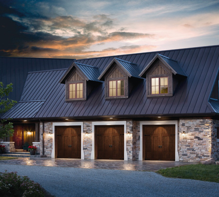 Clopay faux wood garage doors on a stone home